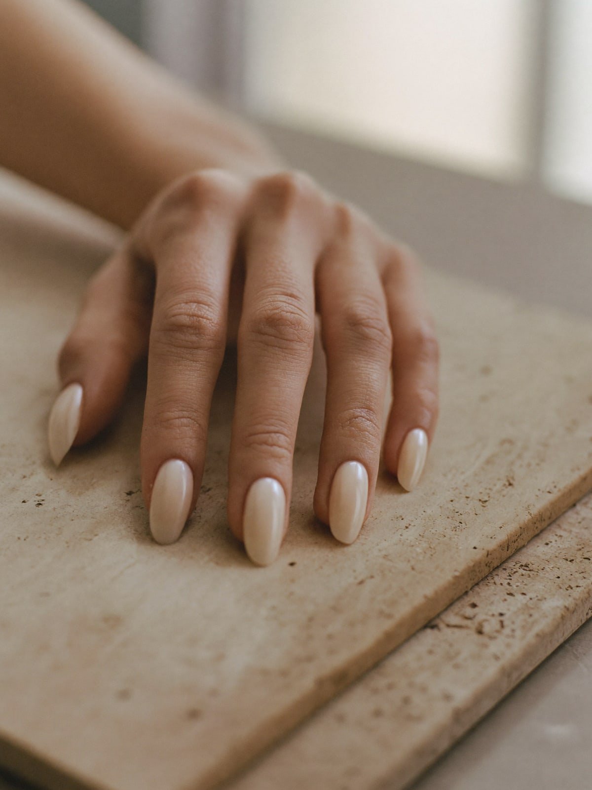 Glazed Milk press-on nails worn on hand — Short almond · Glazed chrome