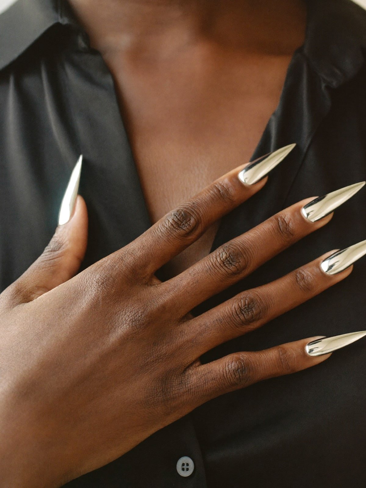 Liquid Silver press-on nails worn on hand — Long stiletto · Mirror chrome