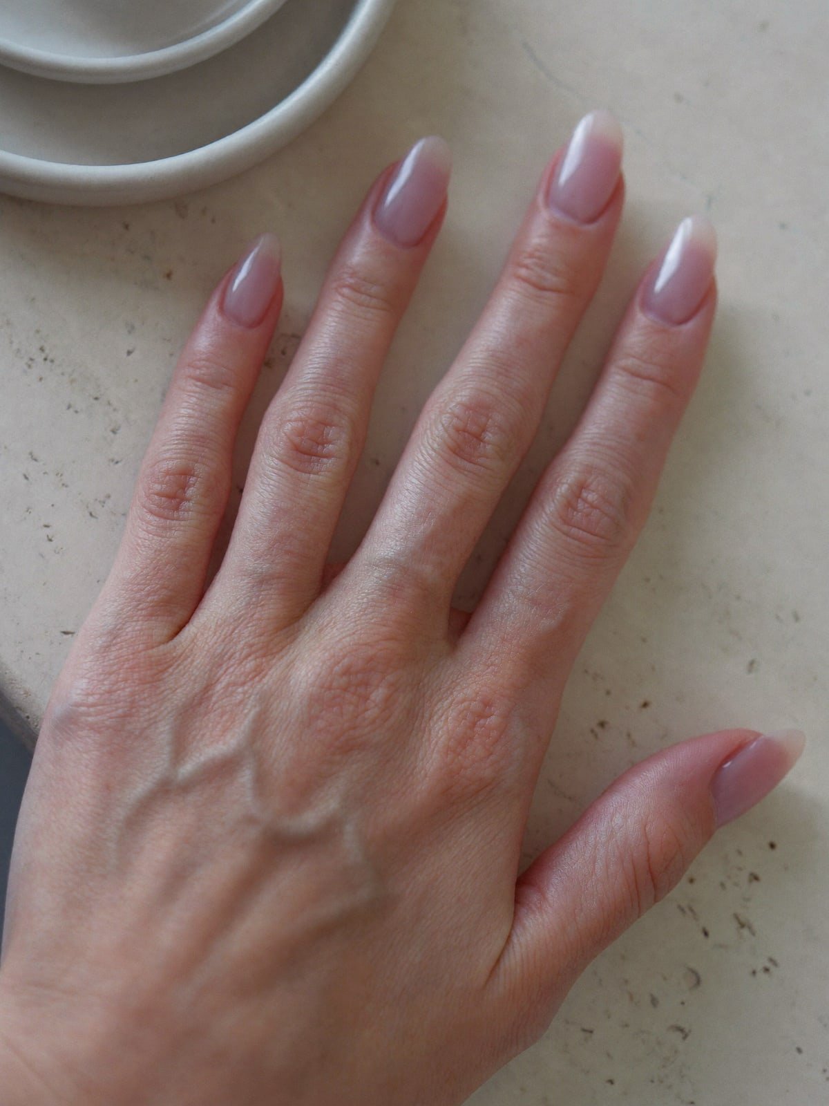Sheer Blush press-on nails worn on hand — Short oval · Baby-pink jelly