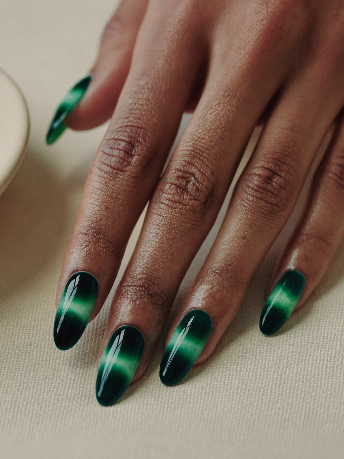 Velvet Cat-Eye press-on nails worn on hand — Medium almond · Emerald magnetic